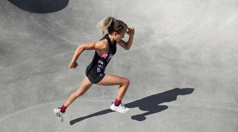 Breaker met enkelbanden in de zomeroutfit sprint perspectief vanaf de zijkant van het betonnen oppervlak van het betonoppervlak