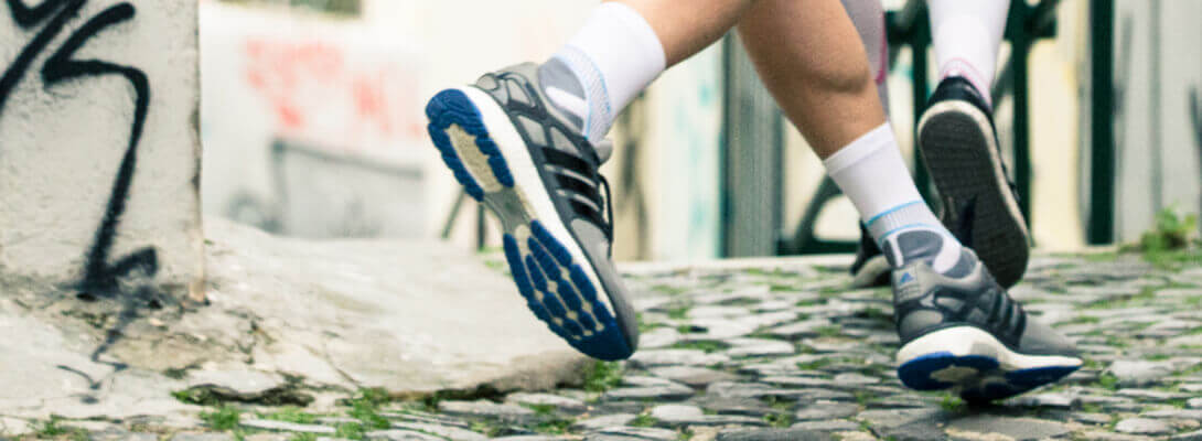 Runner met lopende sokken joggt door de stad - focus op de voeten met product