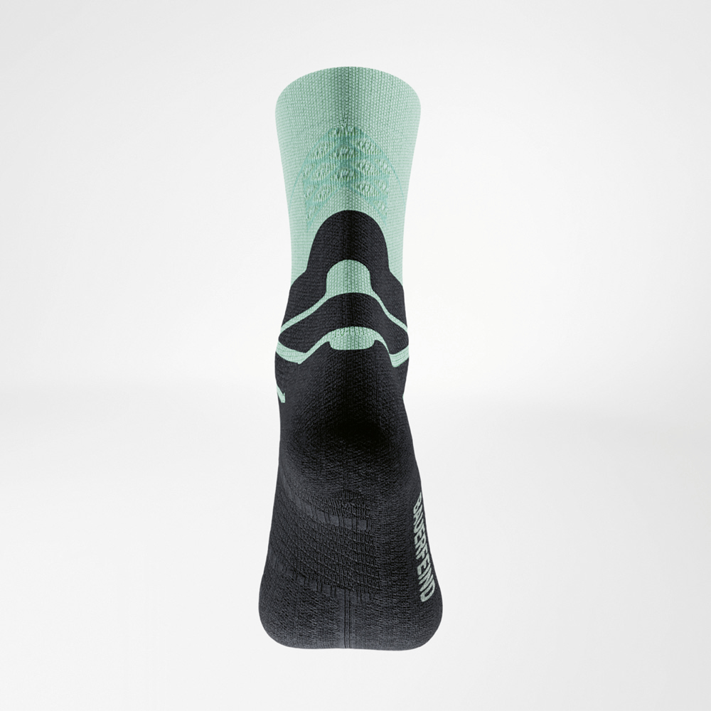 Achteraanzicht van de groen-zwarte Run Performance Midcut sok: groene schacht met 3D-dots, zwarte achillespees-comfortzone en BAUERFEIND-logo aan de zijkant.