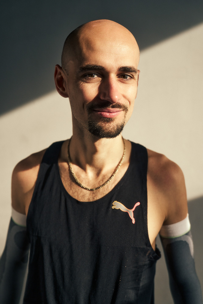 Portret van marathonloper Hendrik Pfeiffer in sportkleding met compressie arm sleeves, gefotografeerd in natuurlijk licht na een training.