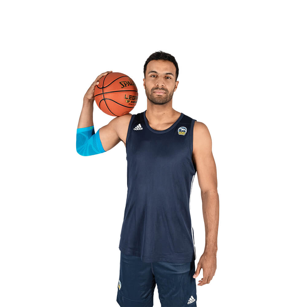 Ellenbogensleeve speelt basketbal Man met basketbal draagt een sportleeve voor de elleboog