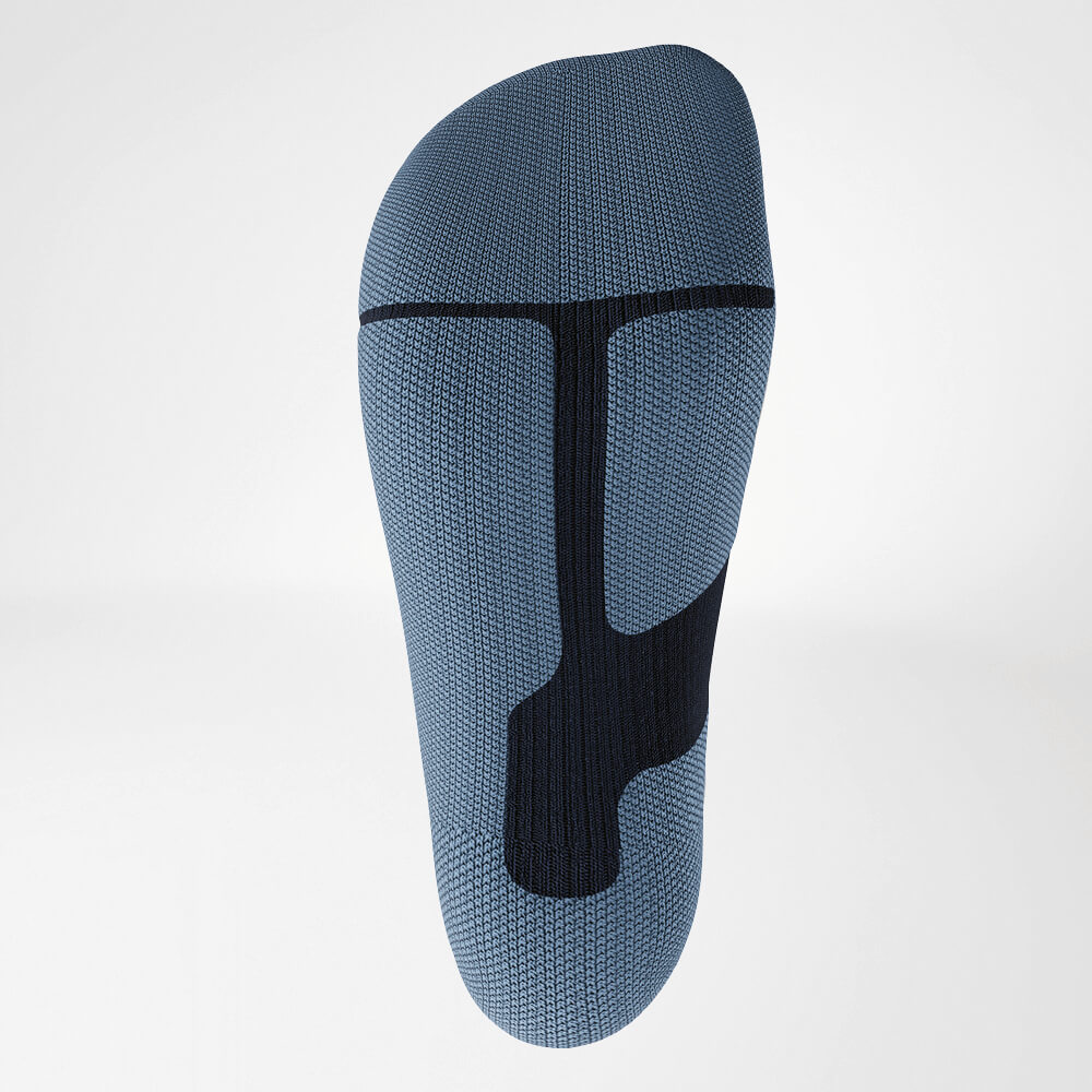 Close-up van de zool van een blauwe ski-compressiesok met ergonomisch breipatroon voor stabiliteit en demping. Ontworpen voor maximaal comfort tijdens intensieve sportactiviteiten.