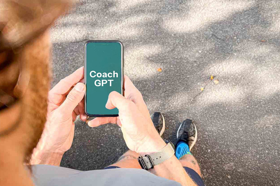 Hardlooptraining met Coach GPT – Digitale Ondersteuning door AI voor je Training. Een loper houdt een smartphone vast met daarop "Coach GPT" weergegeven. De scène toont het gebruik van AI-technologie ter ondersteuning van hardlooptraining.