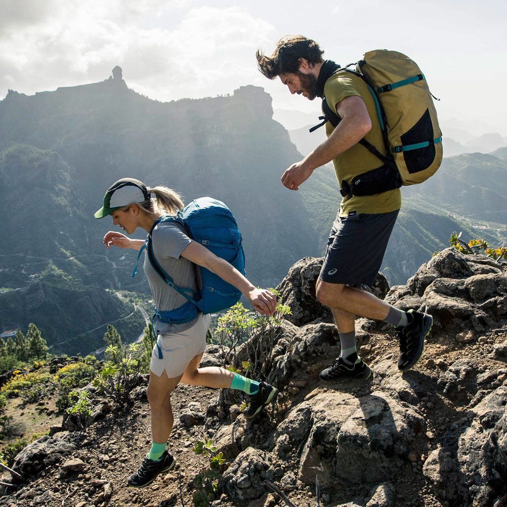 Wandelaars dragen de wandelsokken door de berg lopen voor een bergpanorama