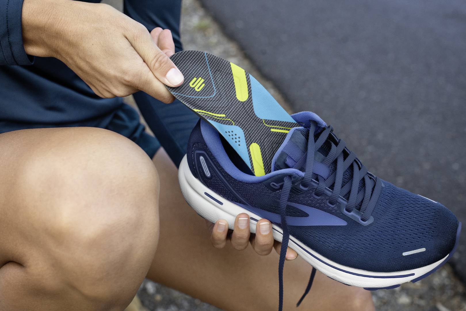 Beveiliging bij elke beurt: met onze enkelbanden Close -up van de voet van een hardloper met enkelverband de straat over een geasfalteerde weg loopt op de achtergrond een heuvel met een kleine berg