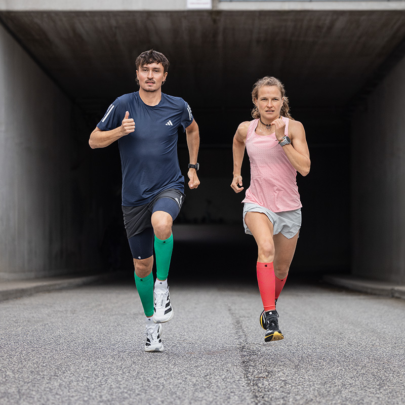 Op tot het einde van de dag! De juiste lopende techniek is nog meer ontspannen Man met langlopende sokken loopt op een promenade naar zonsondergang