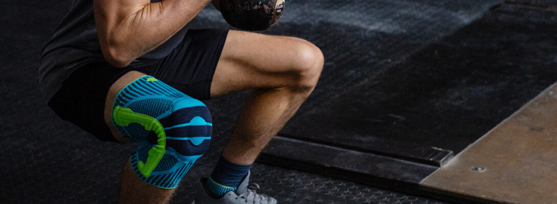 Kniegbandage in fitness Atleten in de sportschool in de squat dragen een knieband voor sport