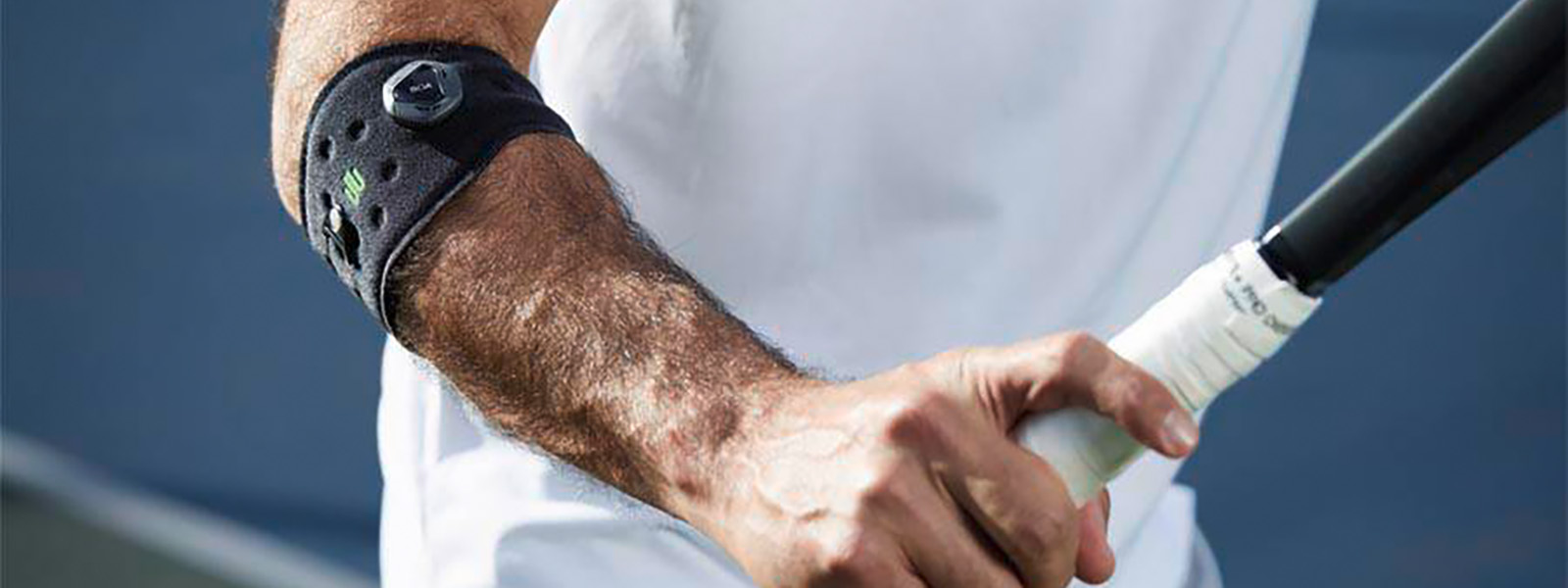 De sportelleboogriem voorkomt een tennisarm en ondersteunt je tennisspel Tennisspeler met een elleboogband heeft een tennisracket in de hand