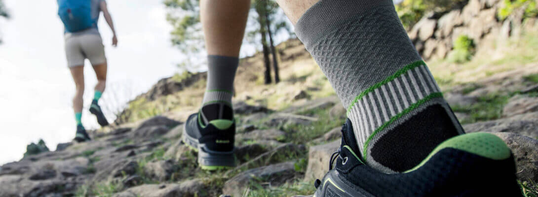 Wandelaars met trekking sokken rennen een berg op	 zoom op de sokken