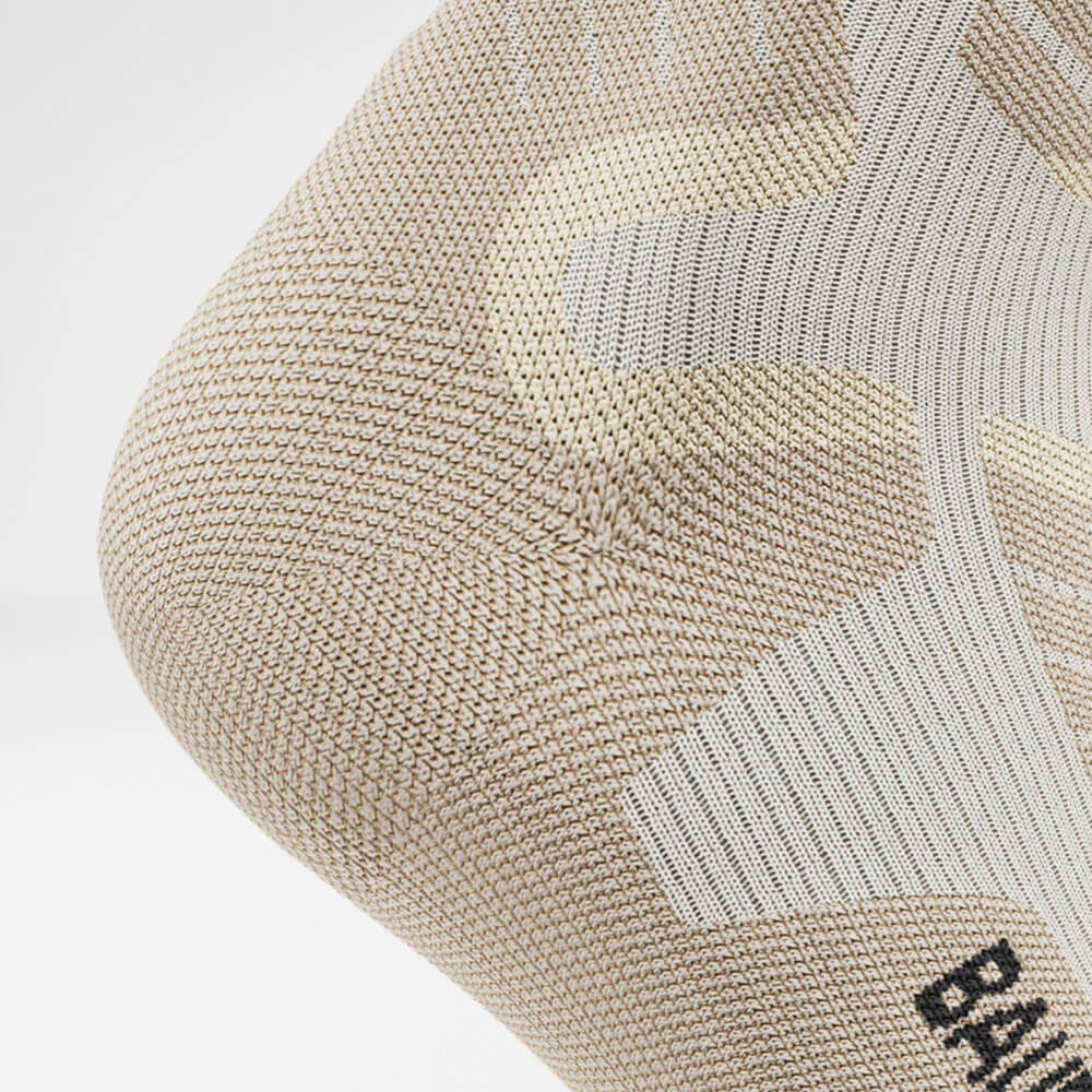 Skisok bergafwaarts met merinowol beige detail Hielbescherming Detail van de hielbeschermingszone van de beige sportsokken voor skiën met merinowol