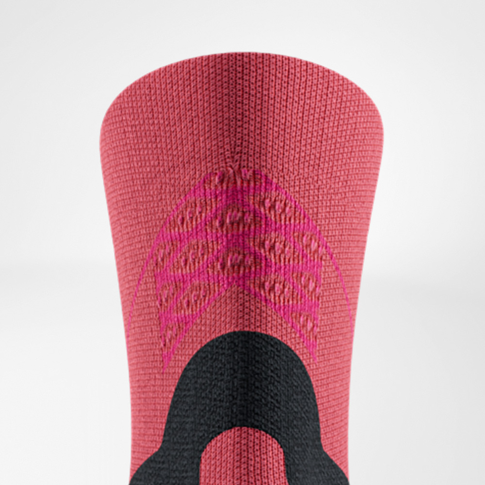 Close-up van de Run Performance Midcut Socks in rood met roze accenten aan de schacht. De breistructuur benadrukt de functionele zones die stabiliteit en ventilatie bieden.
