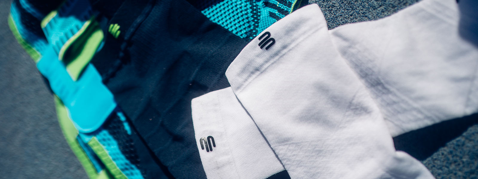 Bauerfeind Sports-producten – Hoogwaardige compressiekleding voor optimale prestaties Close-up van verschillende Bauerfeind Sports producten, waaronder compressiekleding in verschillende kleuren. De afgebeelde textielproducten tonen het iconische logo van het merk.