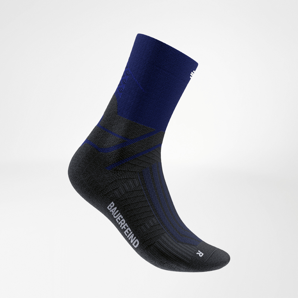 Zijaanzicht van een blauw-zwarte midcut hardloopsok van Bauerfeind met zichtbare steunzones bij de voetboog. De combinatie van technisch materiaal en sportief design geeft dynamisch comfort bij elke run.