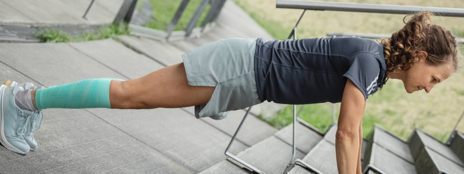 Vrouw zet push-ups op een betonnen vloeraanzicht van diagonaal