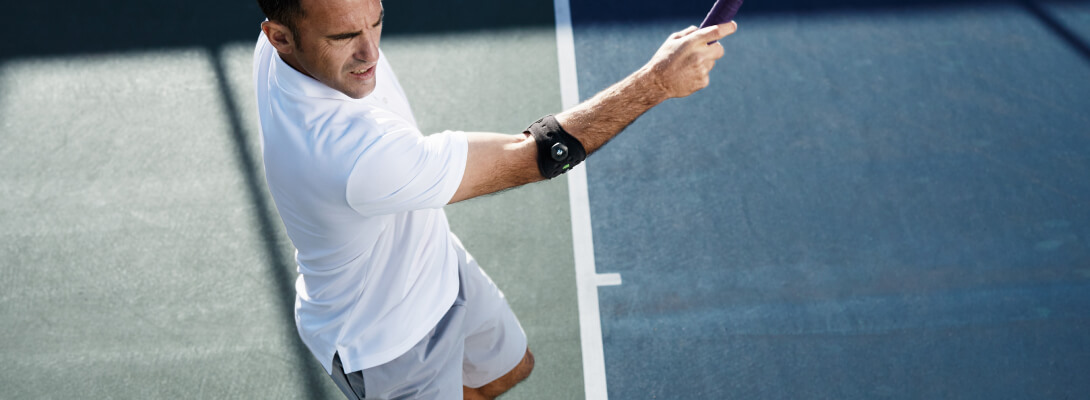 Tennisspeler die een elleboogclip draagt ​​om tennisbogen te verlichten