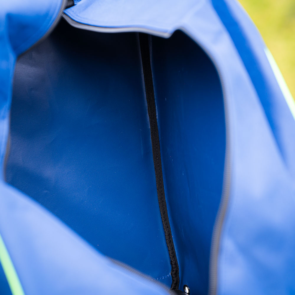 Interieur van de blauwe tas Een close-up van het interieur van een blauwe tas met een zwarte ritssluiting. Het interieur is leeg en de stofdetails zijn zichtbaar.