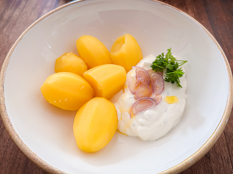 Aardappelen met kwark als licht verteerbare koolhydraatbron voor carbo-loading. Een bord met gekookte aardappelen en kwark, een gezonde en licht verteerbare maaltijd voor carbo-loading voor een halve marathon.