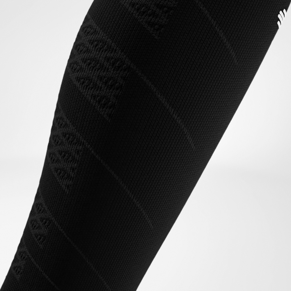 Close-up van een zwarte Run Performance Compression Sleeve op het onderbeen, met een fijn breiwerk dat gerichte compressie biedt en de kuitspieren ondersteunt tijdens het hardlopen.