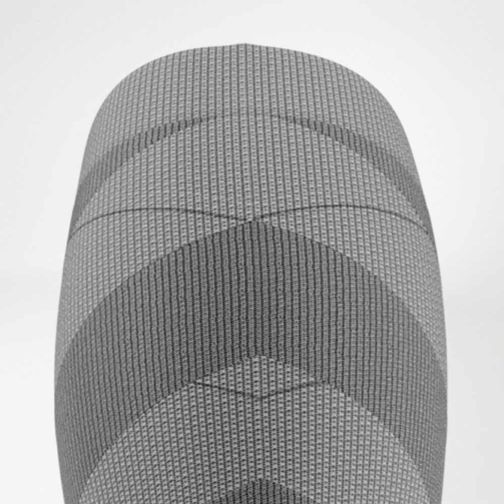 Gerichte druk – tot onder de knie geoptimaliseerd Bovenaanzicht van het bovenste deel van de ski-compressiekous voor dames met geribde structuur en graduele compressiezones rond de knie.