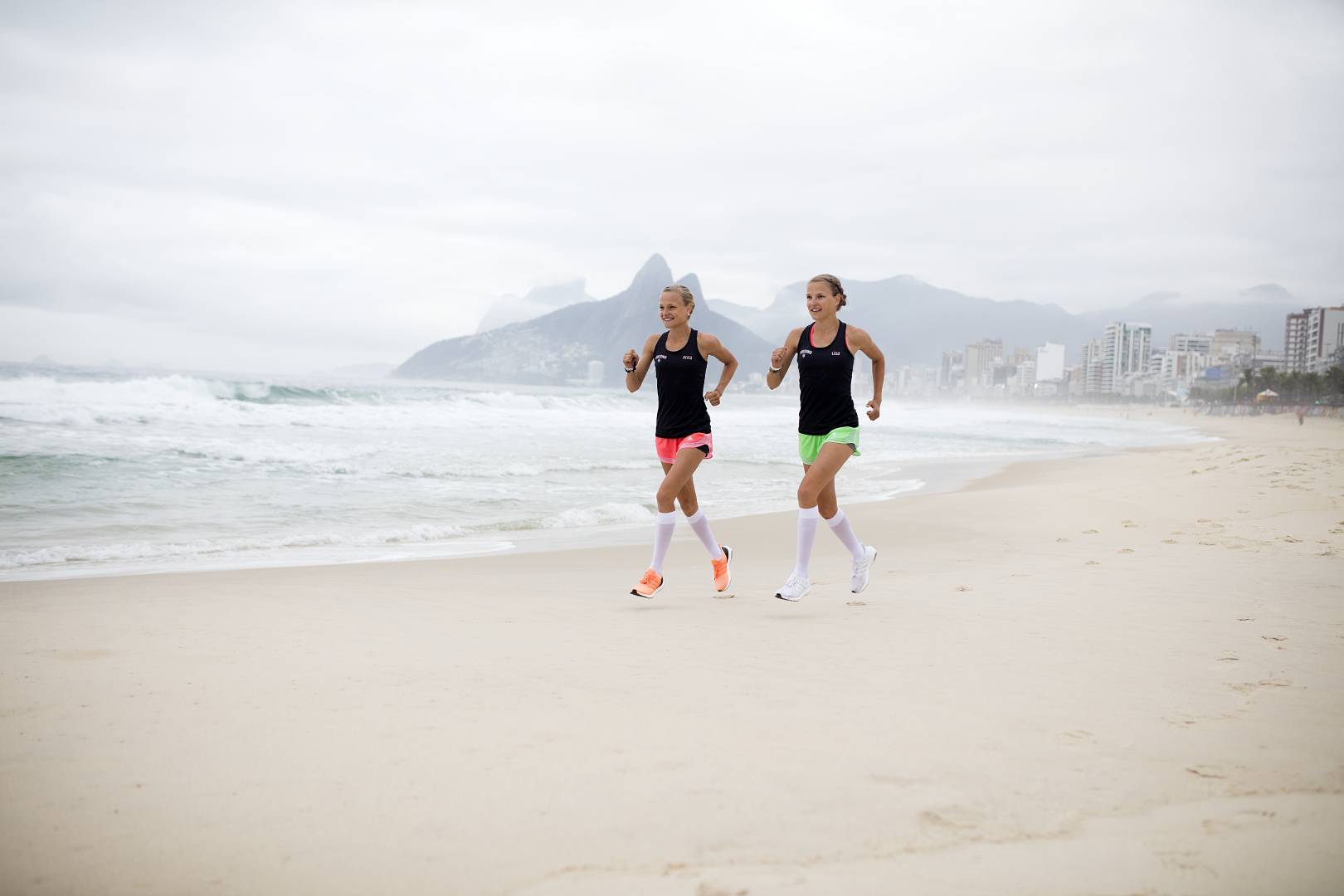Twins lopen op het strand van Rio met witte loop sokken