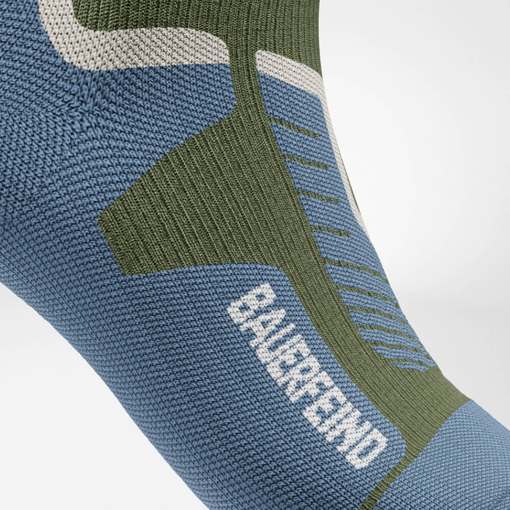 Close-up van de wreef van een groene ski-compressiesok met versterkt, ergonomisch breipatroon. Biedt optimale ondersteuning en drukverdeling voor maximaal comfort tijdens intensieve sportactiviteiten.