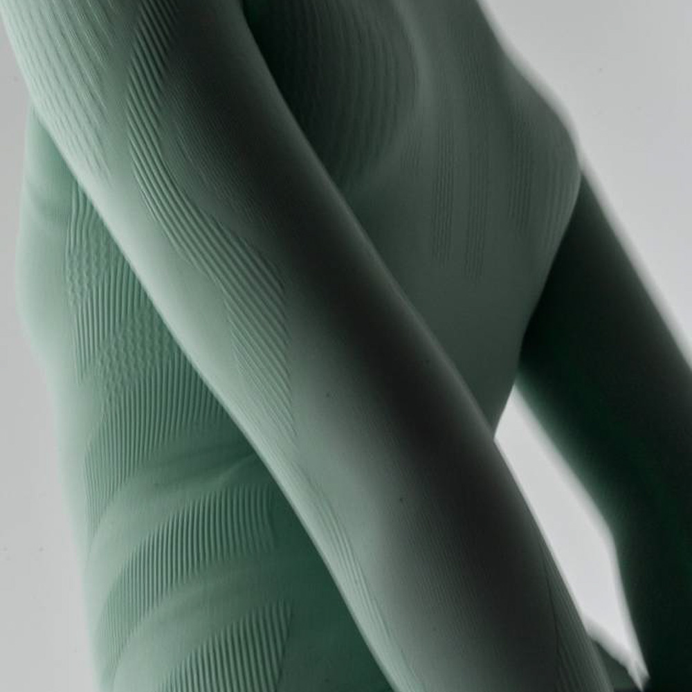 Lichtgroene sport- en compressietop Bovenlichaam van een vrouw die een lichtgroene sporttop draagt