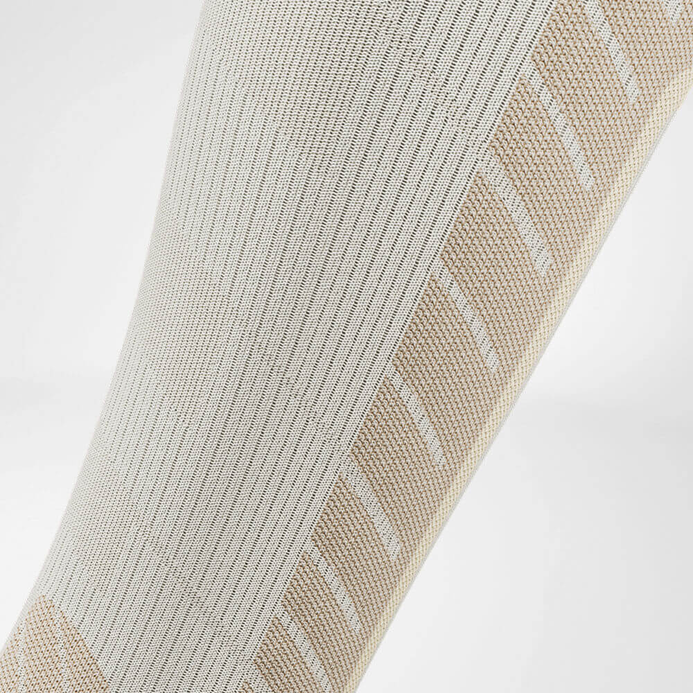 Skisok downhill met merinowol beige detail compressiezone Detail van de kuitcompressiezone van de beige sportsok voor skiën met merinowol