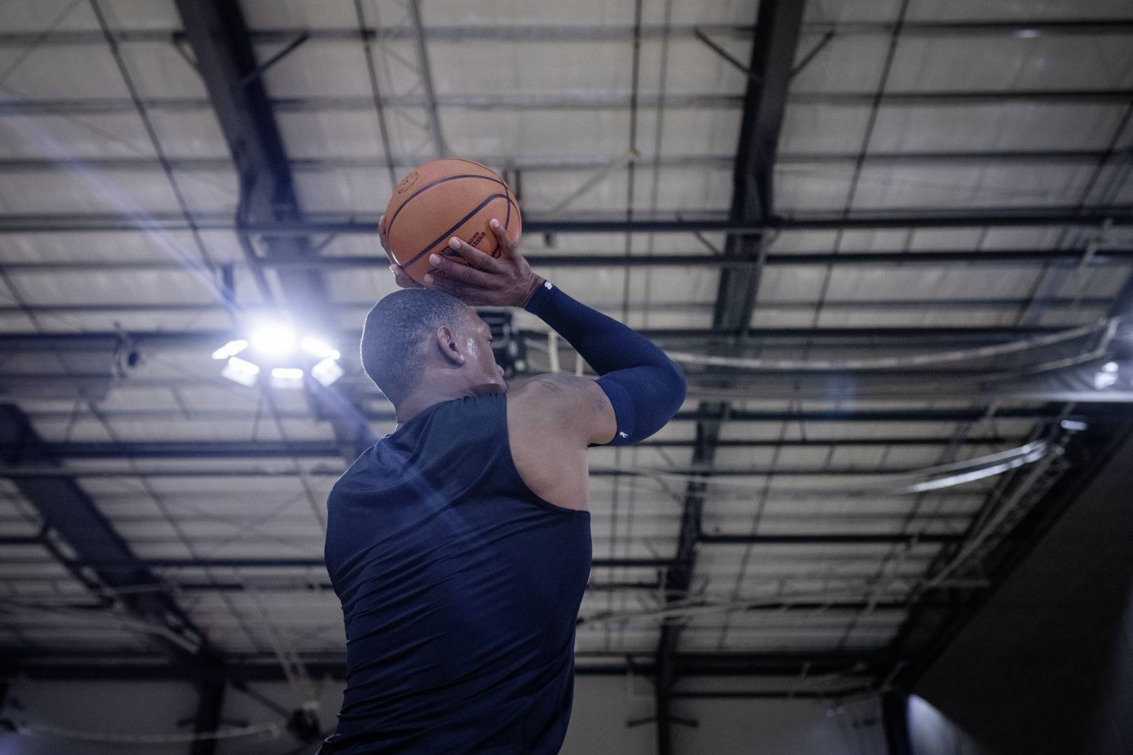 Onze schietende slaap voor de speciale momenten: de compressiearm slaap "Dirk Nowitzki" Basketbalspelers met een blauwe armenleeve in een sportzaal beginnen met hun handen boven het hoofd naar de worp