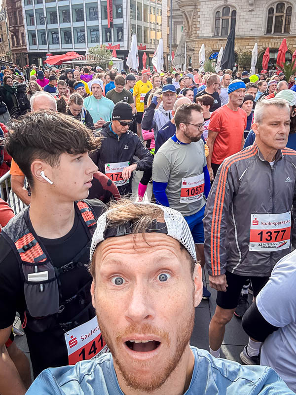 Selfie van een deelnemer bij de start van de Mitteldeutscher Marathon 2024 in Halle Een opgewonden deelnemer maakt een selfie vlak voor de start van de Mitteldeutscher Marathon 2024 in Halle. Om hem heen verzamelen veel andere hardlopers zich, klaar voor de halve marathon.