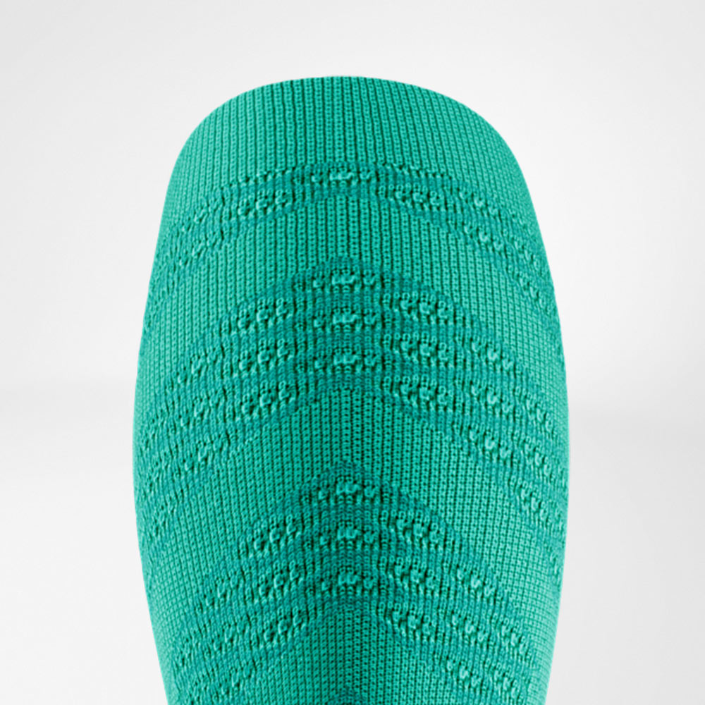 Detail van een felgroene compressiesleeve met duidelijk zichtbaar structuurpatroon. Het materiaal oogt dynamisch en straalt stabiliteit en energie uit voor intensieve trainingen.
