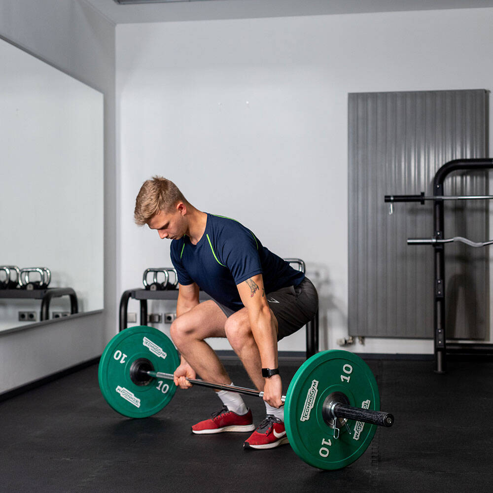 Man in de sportschool in Kreuzlift met een barbell