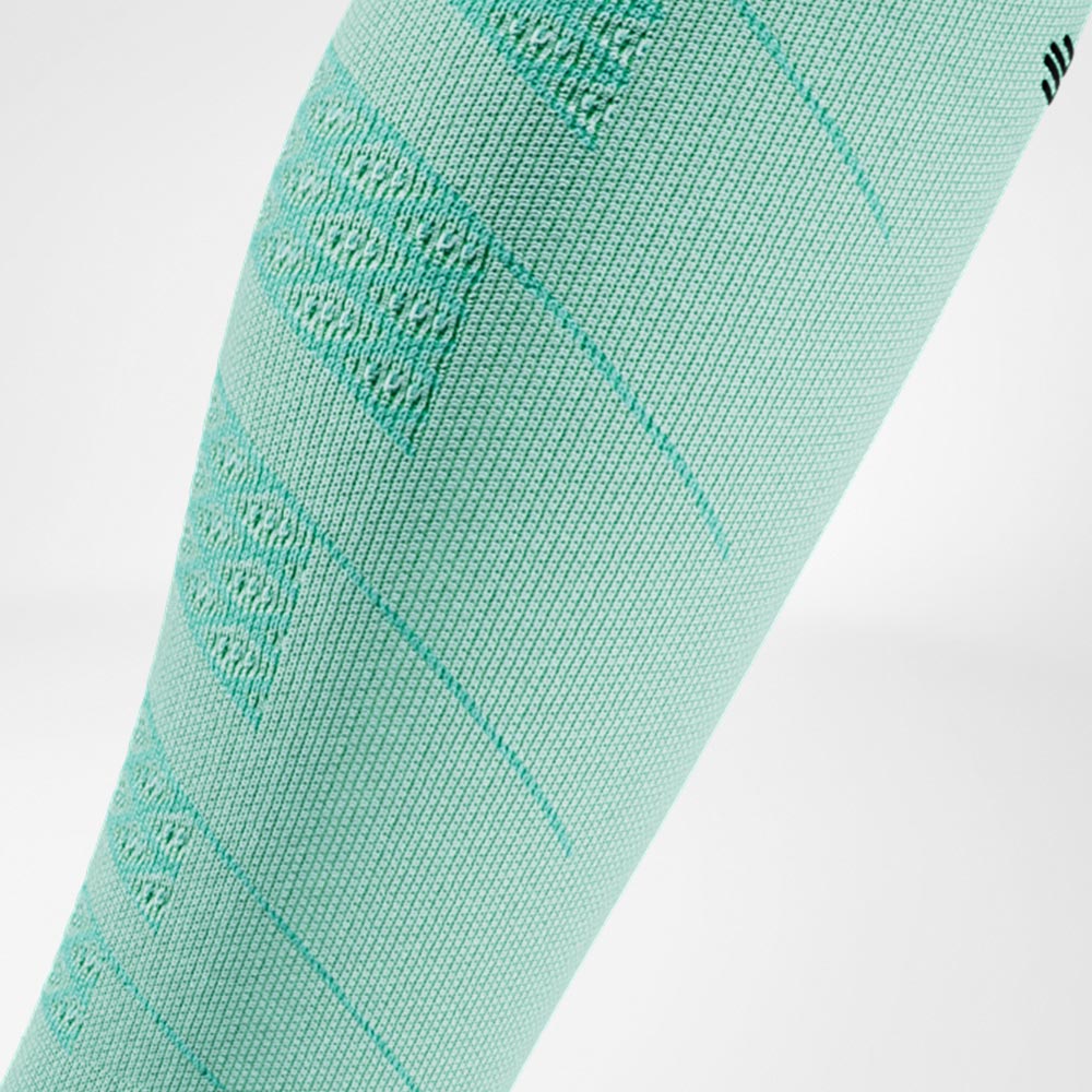 Close-up van een mintgroene Run Performance Compression Sleeve op het onderbeen, met een ademende breistructuur die zorgt voor lichte en comfortabele compressie.