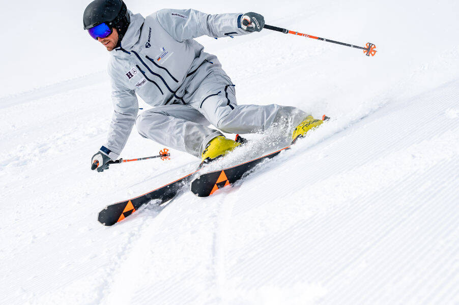 Skiërs in een grijs pak met een lichte hellende positie voor hem kunnen worden herkend door het groefpatroon van de gestagneerde hellingen