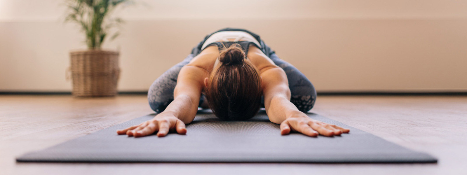 Yoga tegen rugpijn kan erg ontspannend zijn Diep -oprelaxed vrouw heeft haar hoofd achter haar armen op de mat gelegd