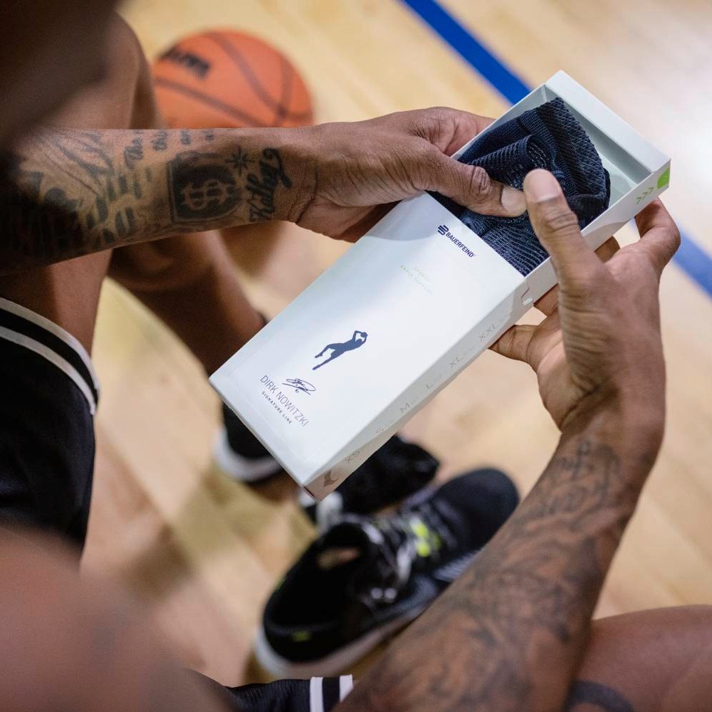 Uitpakken, aantrekken, presteren! Een sporter opent een doos met de Dirk Nowitzki Special Edition enkelbrace.