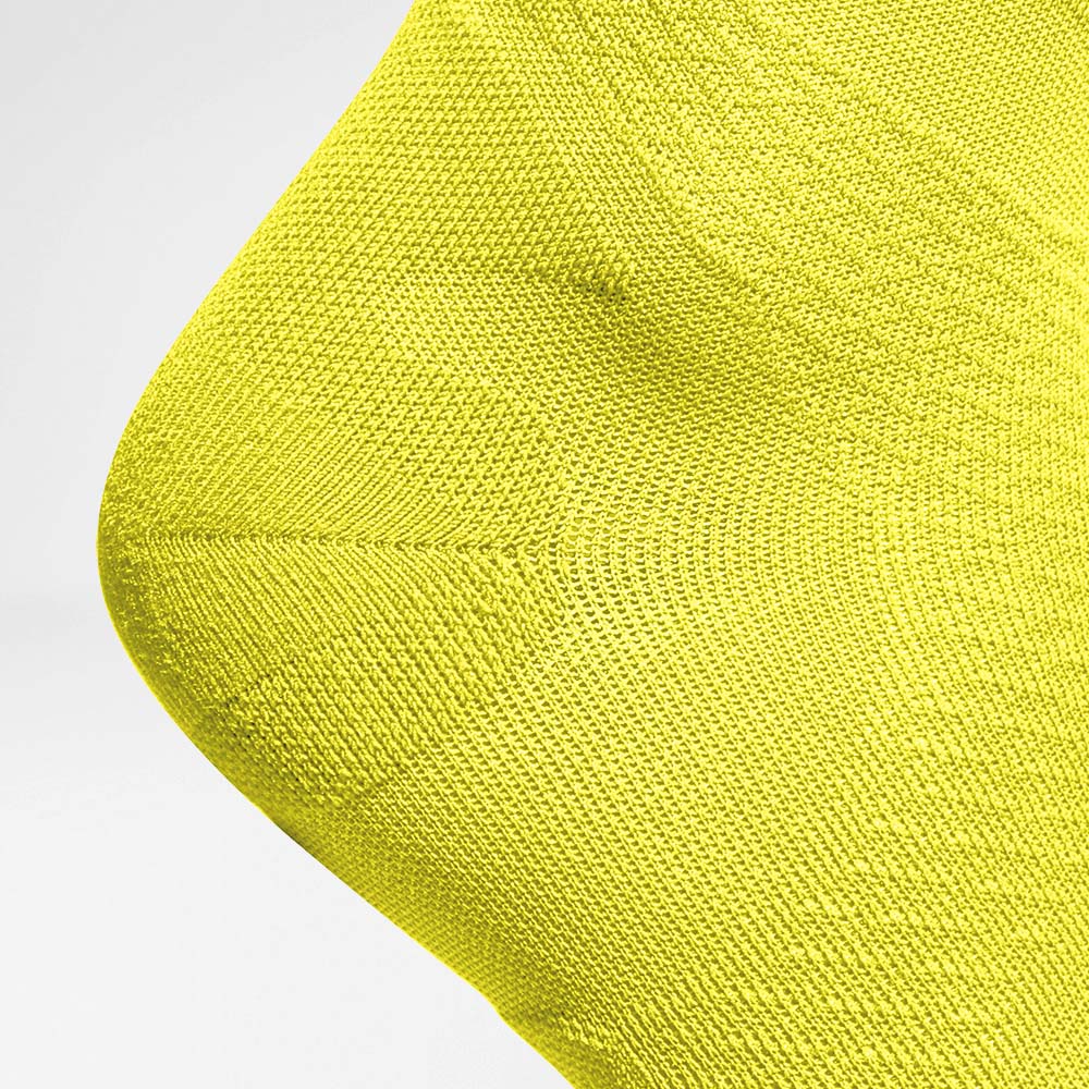 Detailansicht der Fersenschutzzone der mittellangen luftig gestrickten gelben Laufsocken