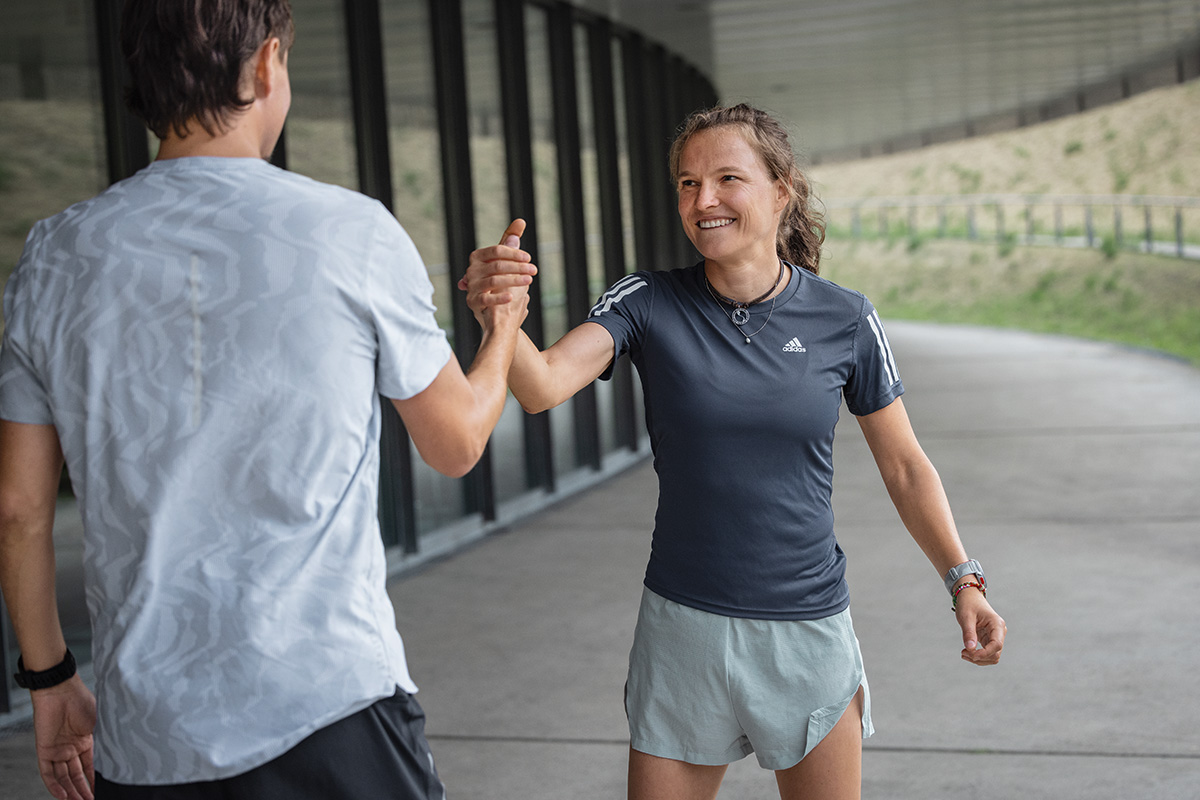 Vrouw in de zomer loopt outfit op de vloer en kijkt uit naar de zonsondergang