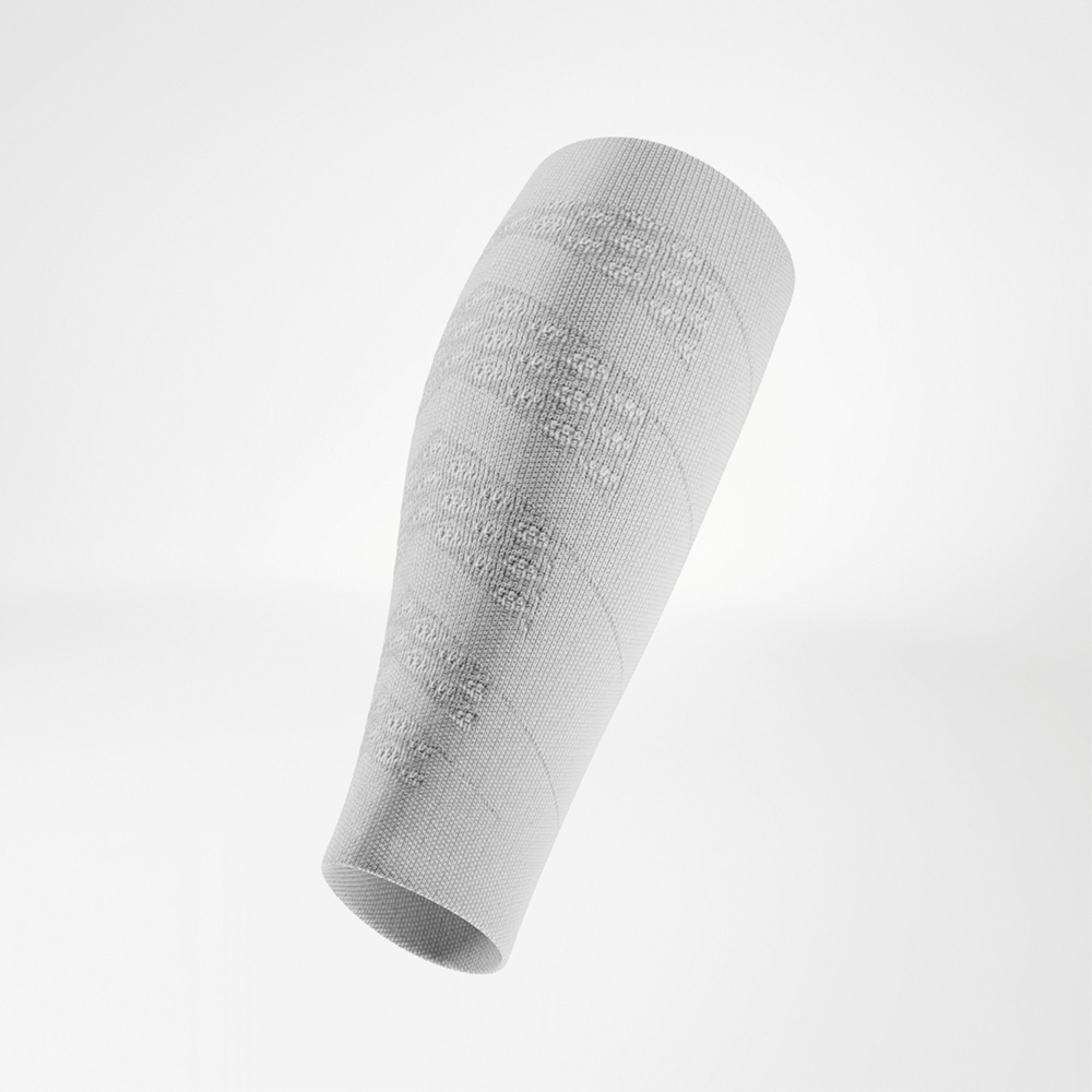 Witte compressiesleeve in schuine weergave, de gevormde pasvorm sluit perfect aan op de kuit, voor ondersteuning en dynamische bewegingen.