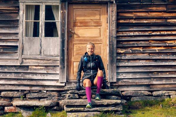 Traill Runner Johanna Aström zit voor een hut