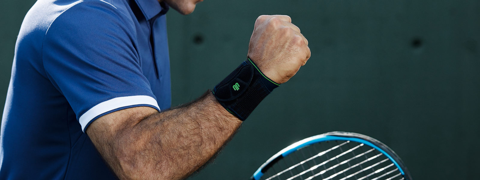 Meer kracht voor de polsen met sportpolsondersteuning Tennisspeler met een zwarte polsbandageballen de vuist