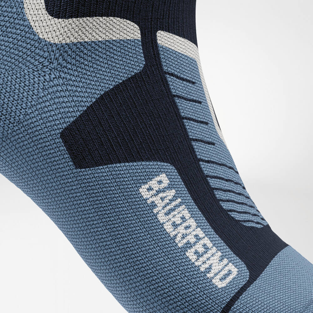 Close-up van de wreef van een blauwe ski-compressiesok met versterkt breipatroon voor optimale ondersteuning en drukverdeling. Perfect voor lange dagen op de piste.