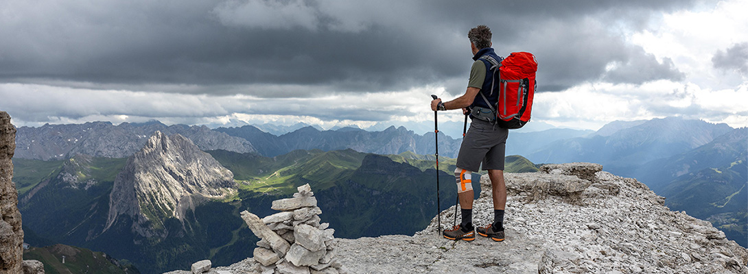 Bergbeklimmer op een bergtop Bergbeklimmer op een bergtop die een outdoor kniebandage draagt