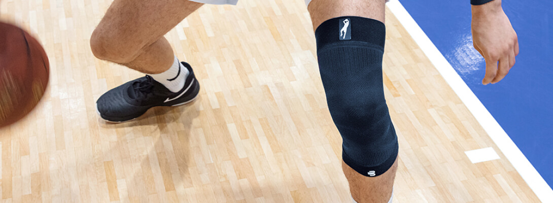 Gedetailleerd uitzicht op de benen van een basketbal speelman die een knie mouw Dirk Nowitzki draagt