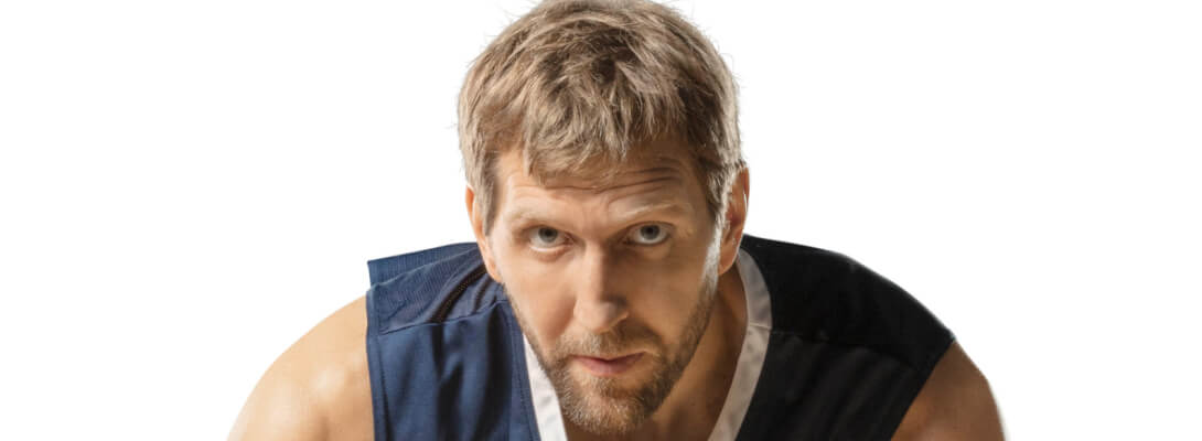 Dirk Nowitzki aan het basketballen met Bauerfeind Afbeeldingssectie van Dirk Nowitzki in een blauwe trui die in de camera kijkt