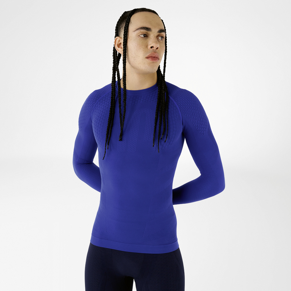 Vooraanzicht van een man in een blauw, nauwsluitend langmouwshirt met gestructureerd ontwerp