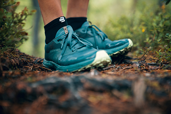 Sluit bovenste wandelschoenen op een bosbodem