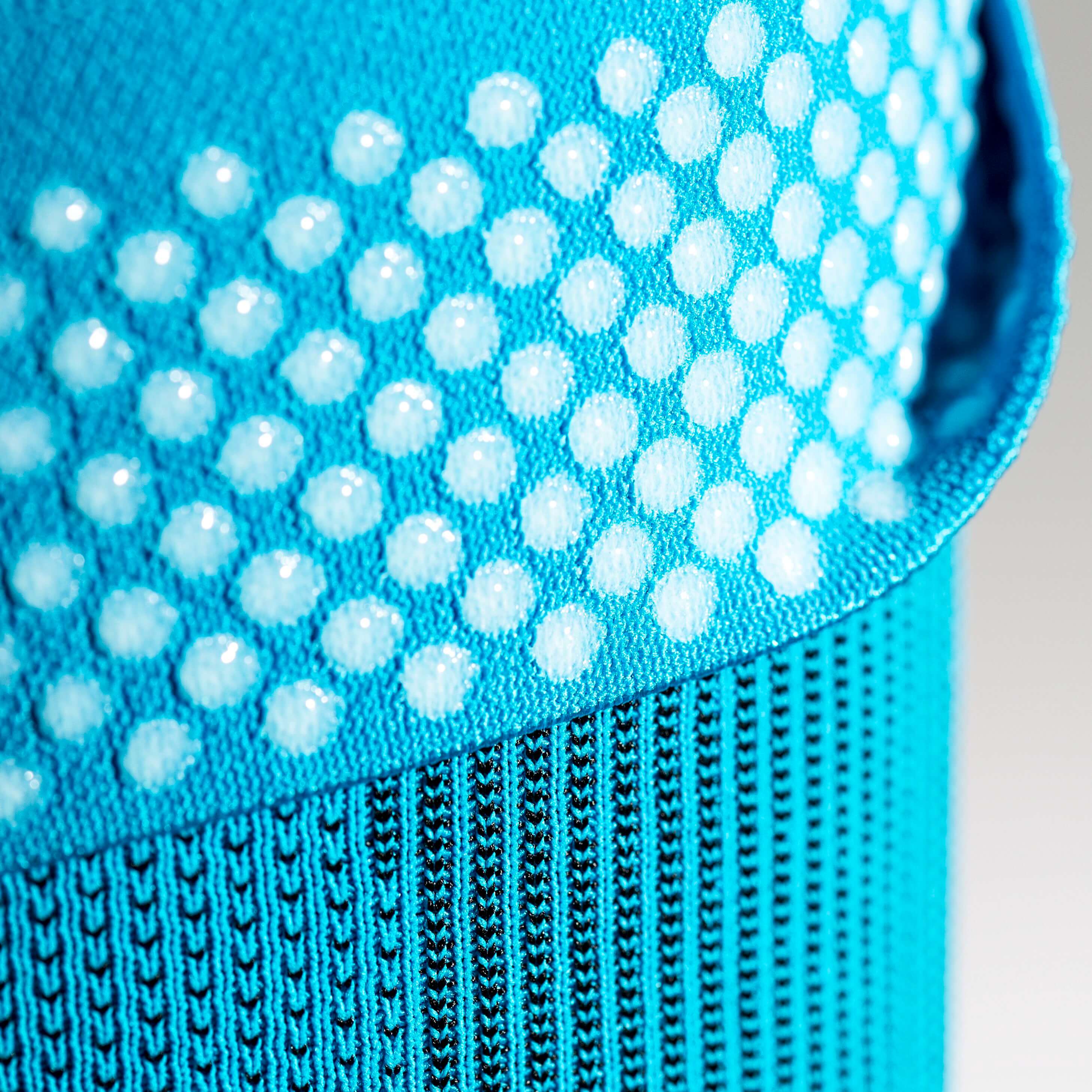 Knie Sleeve Rivera Detail Grip Technology Gedetailleerd uitzicht op een blauwe knie met het bovenste deel en uitzicht op de siliconengenezing Nops