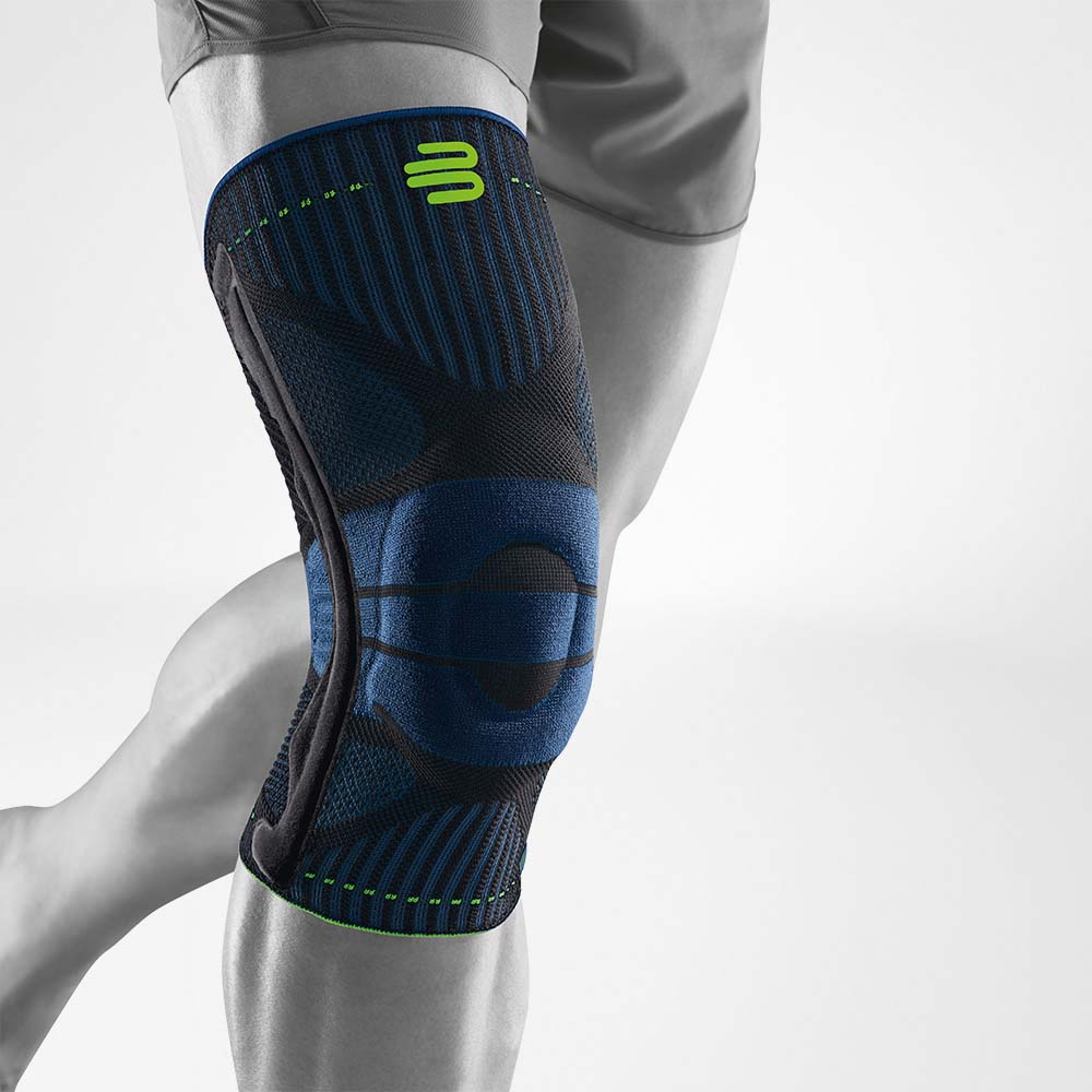 Volledig uitzicht op een blauwe en zwarte knieband voor sport op het gestileerde grijze been