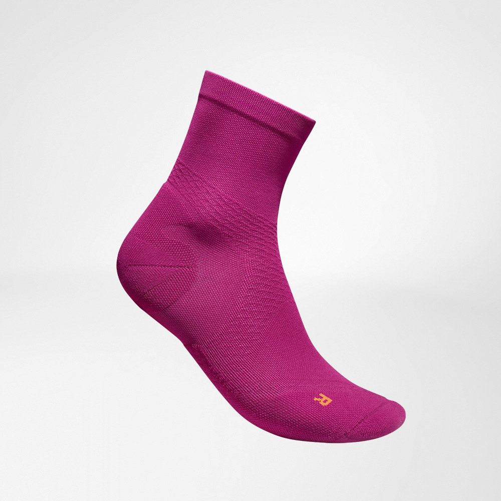 Lateraal compleet uitzicht op de roze, medium-lengte luchtige gebreide lopende sokken