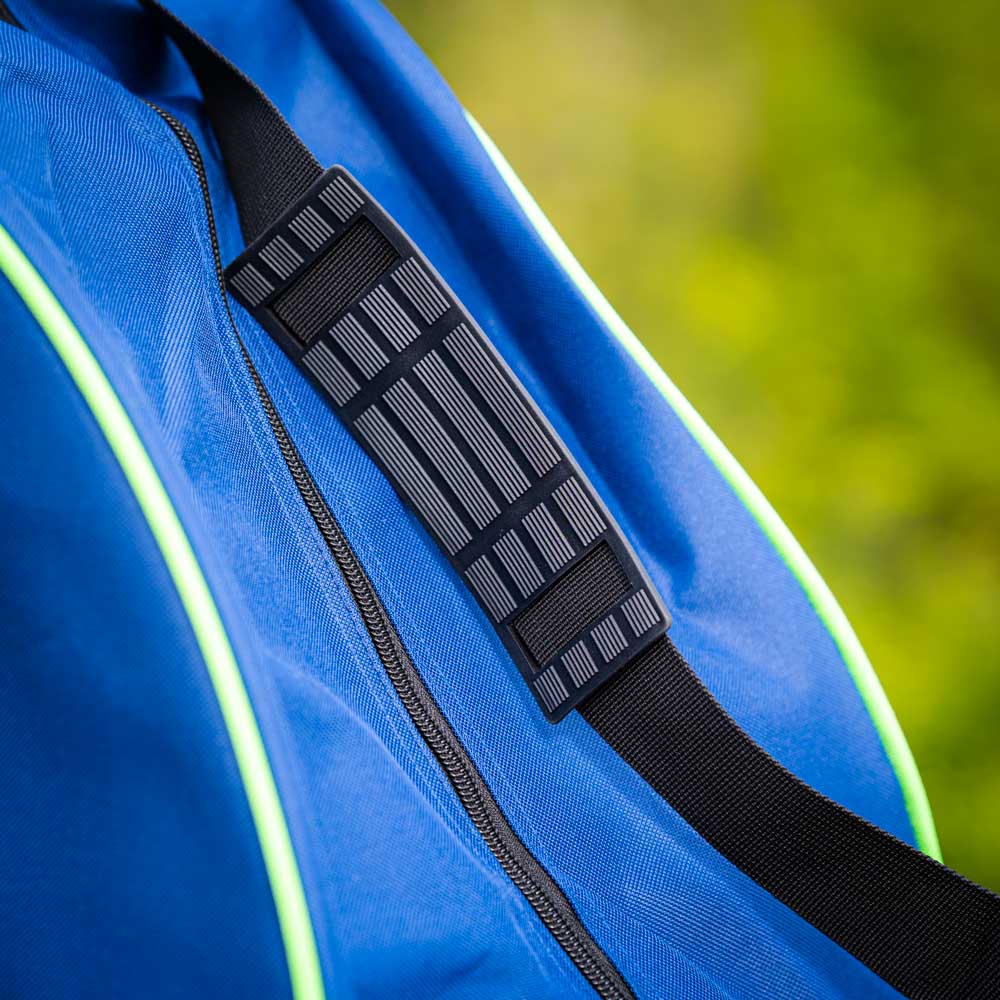 Gevoerde schouderriem van de tas Close-up van een gevoerde zwarte schouderriem op een blauwe tas met groene accenten. De riem heeft een gestructureerd oppervlak voor extra grip.